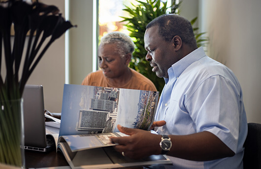 A joint tenants couple looking through property sales brochures 