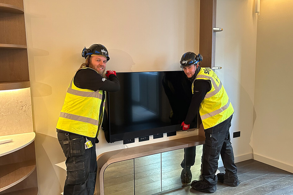 Two Sky engineers fitting a Sky Glass TV at TCRW SOHO