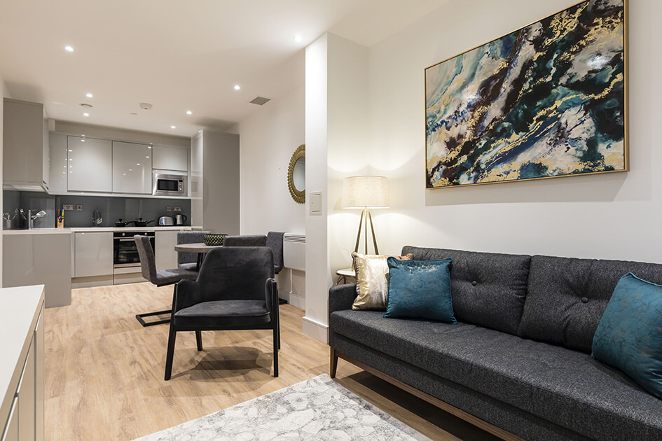 A sofa, dining table and kitchen area in a show apartment at Westgate House in Ealing.