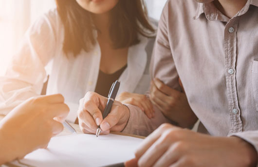 Overseas couple filling out their property reservation paperwork