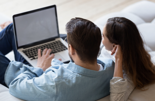 Couple searching for a property on their laptop