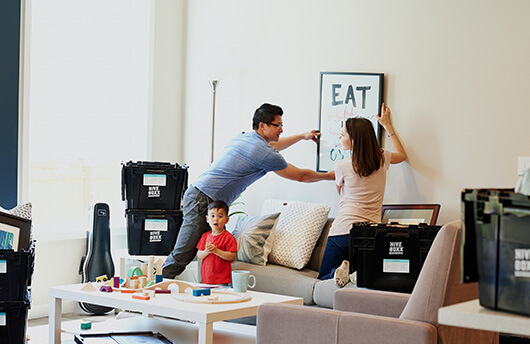 Family hanging up a picture in their new build apartment