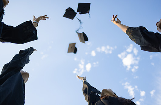 Students throwing their graduation hats in the air.