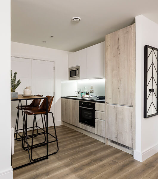 A kitchen area with breakfast bar in a show apartment at Newacre House in East Grinstead