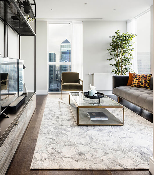 A living area with a view of Canary Wharf at Harbour Central by Galliard Homes