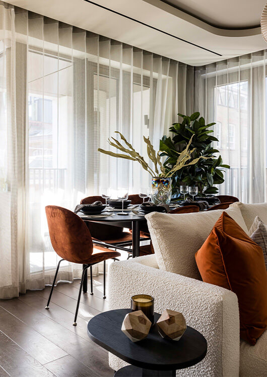 A close-up of a sofa and dining table at a flat for sale in London by Galliard Homes
