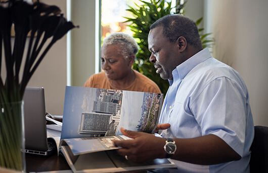 A joint tenants couple looking through property sales brochures