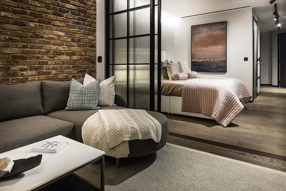 A living and bedroom area separated by a sliding door at a show apartment at The Stage in Shoreditch