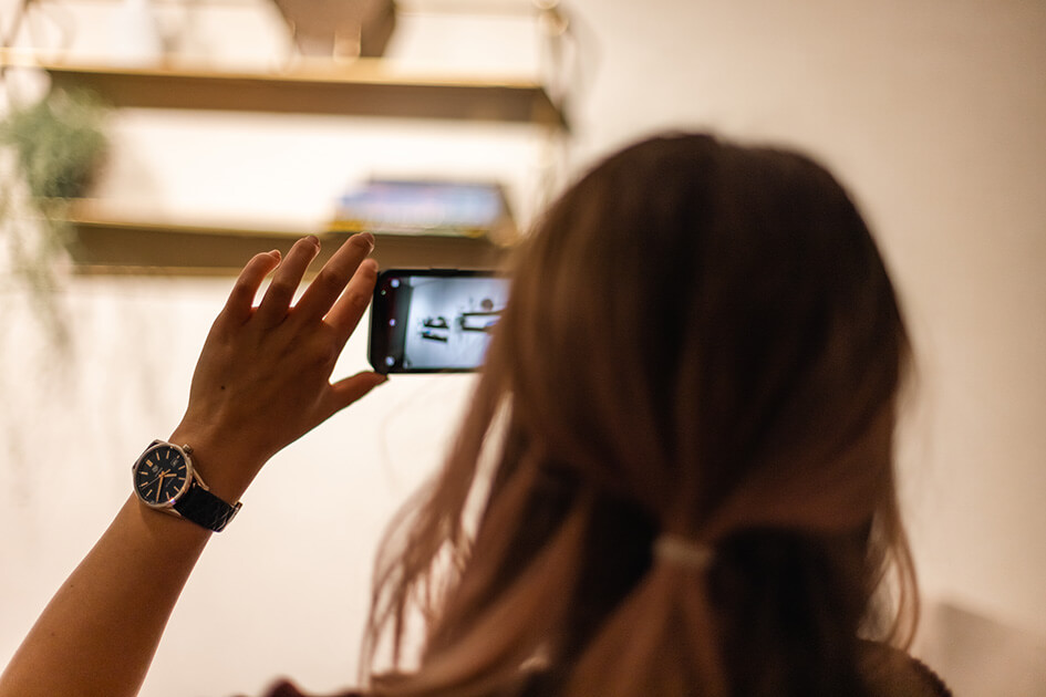 Interior designer, Emily, taking a photo of a shelf in a show apartment at The Stage in Shoreditch