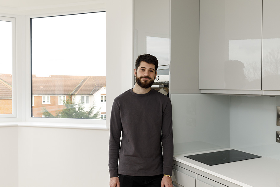 First-time buyer standing in his new kitchen at Papermill House, Romford