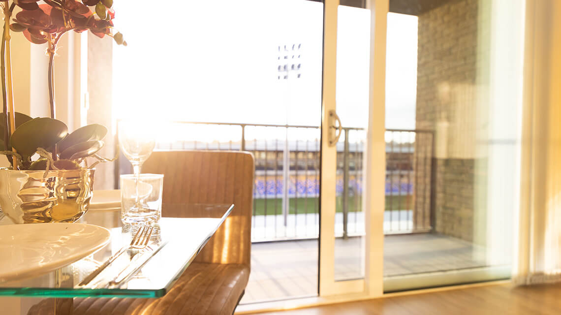 A dining table with views of the AFC Wimbledon pitch at Wimbledon Grounds by Galliard Homes