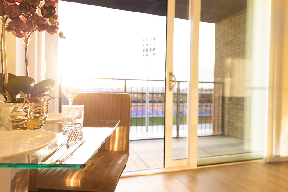 A dining table with views of the AFC Wimbledon pitch at Wimbledon Grounds by Galliard Homes