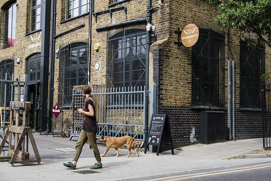 Person with dog walking past Beer Merchants Tap, Hackney Wick