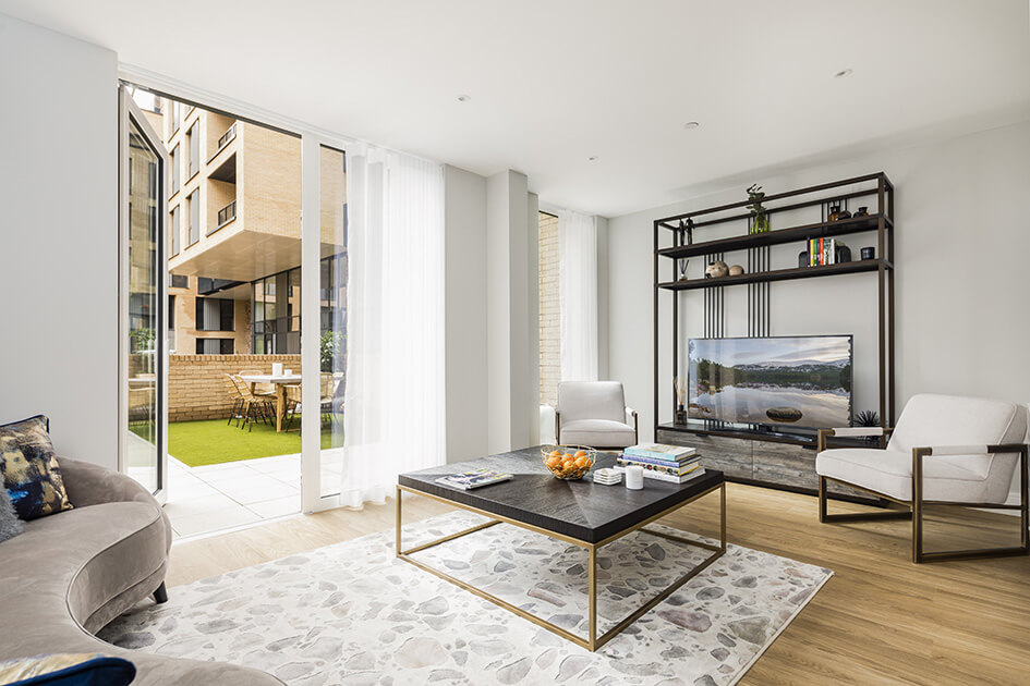 A living area and garden at a Wimbledon Grounds show maisonette by Galliard Homes.