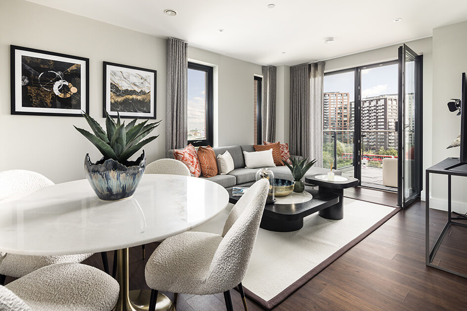 A stylish living and dining area at an Orchard Wharf show apartment with doors overlooking the River Lea.