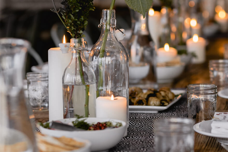 a dining table with candles and party food