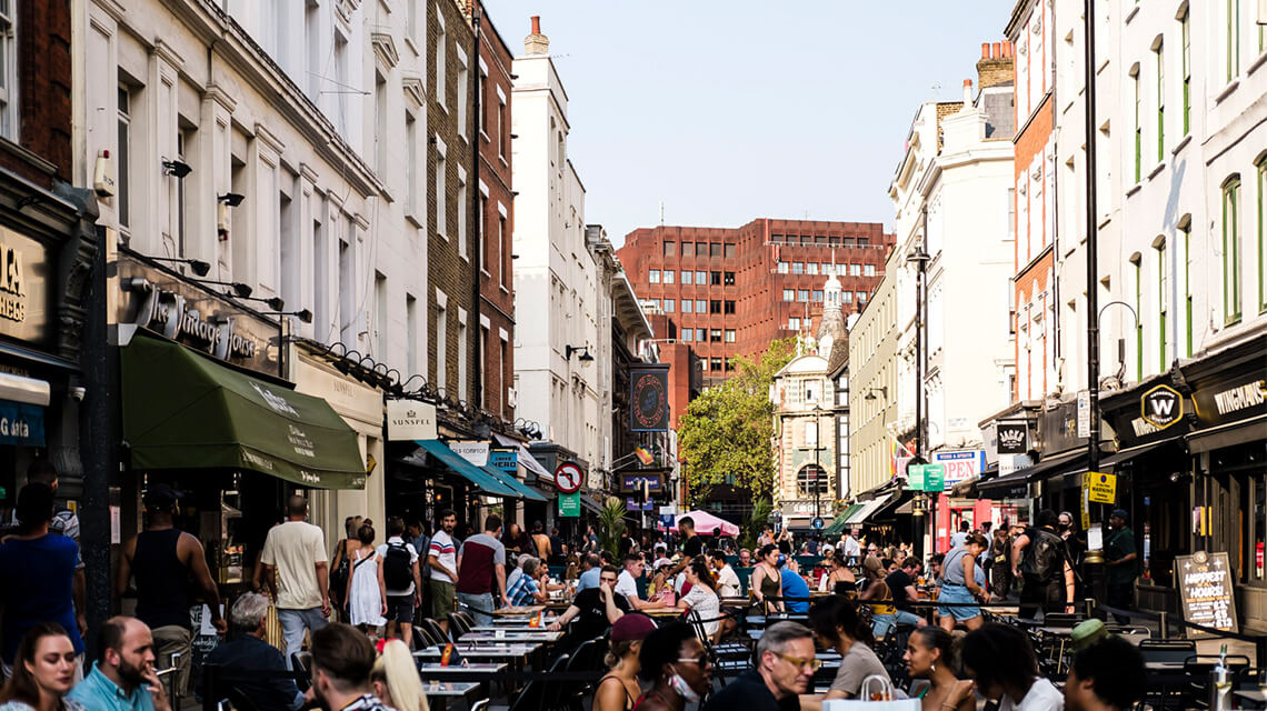 Diners eating outside restaurants in Soho, London.