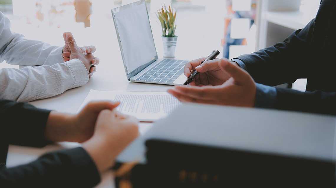 A laptop on a desk in a meeting.