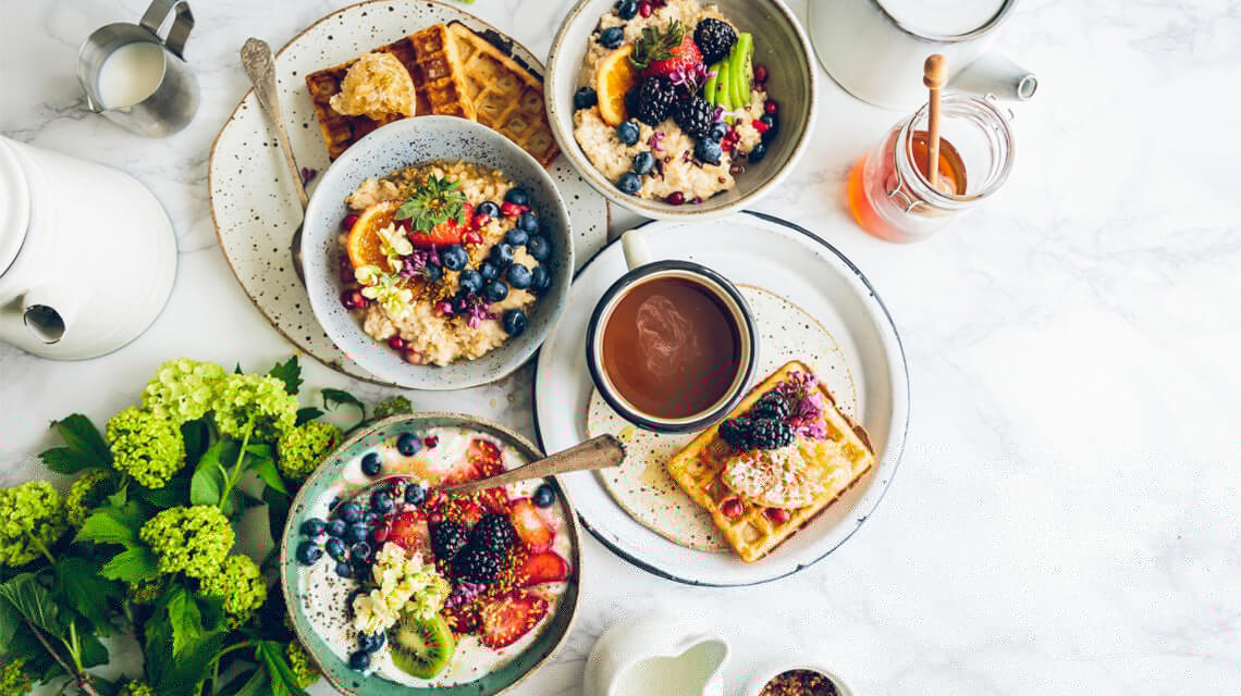 A colourful brunch table with various foods.