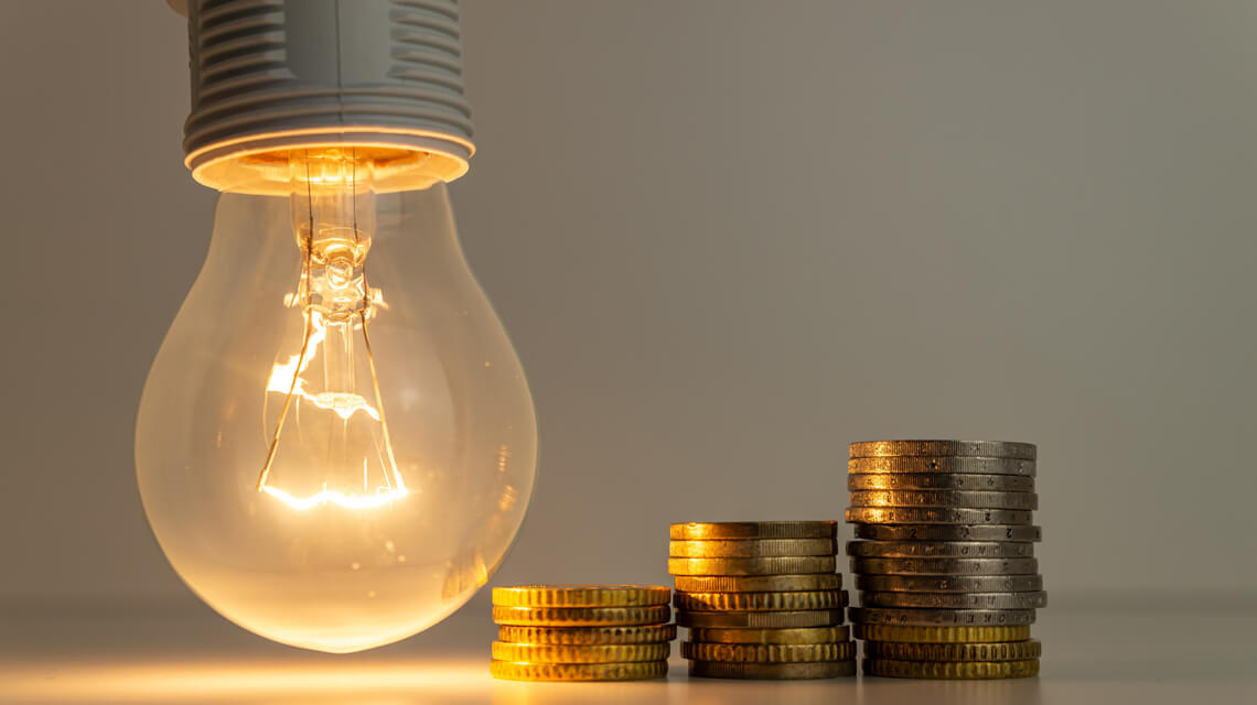 Lightbulb and stacks of coins.