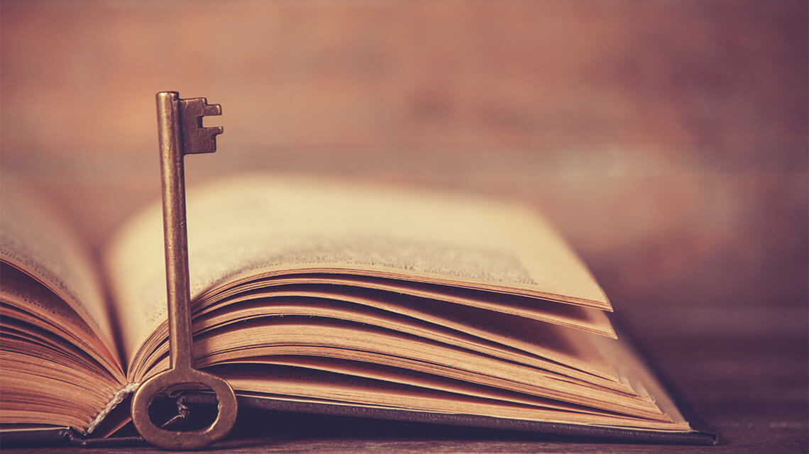 A key resting against an open book symbolizing a glossary of buy-to-let terminology