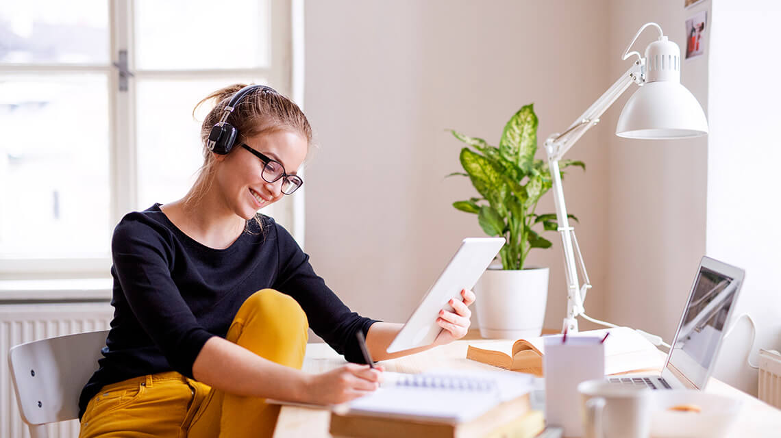 Woman listens to music while she works from home, Galliard Homes