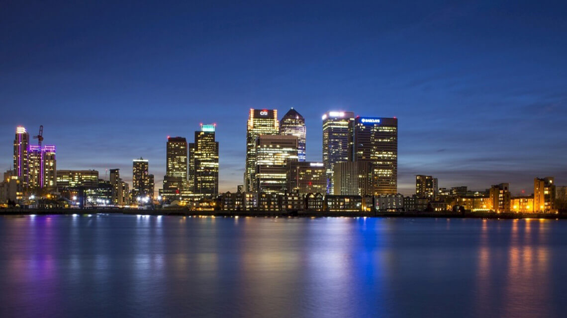 A nighttime shot across the Thames of Canary Wharf