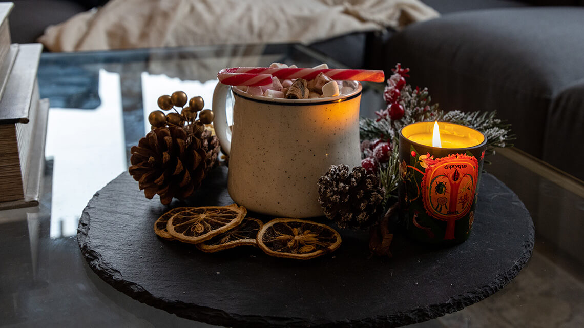 A festive hot chocolate and candle on a coffee table at a show apartment at Wimbledon Grounds.