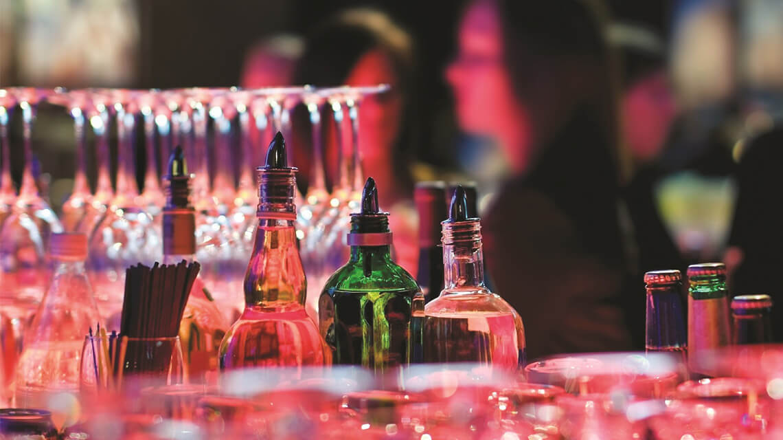 A bar area with bottles and glasses.