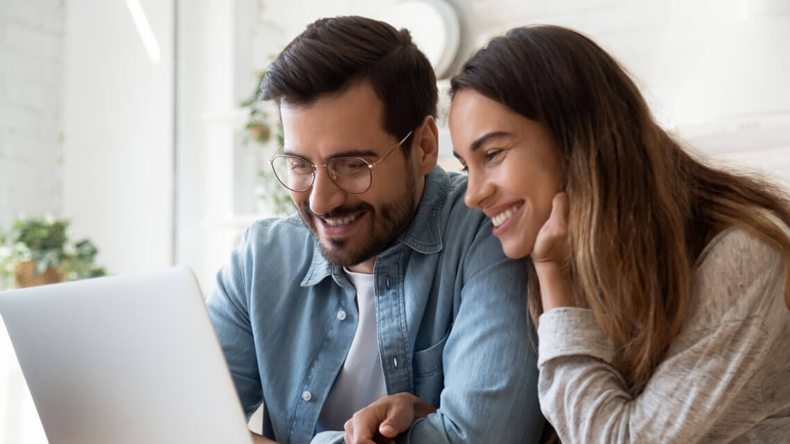 Couple searching for a property on their laptop