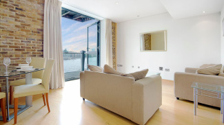 Living room and balcony with river view at a Tea Trade Wharf show apartment, ©Galliard Homes.