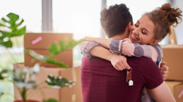 Couple hugging after moving in to their new home