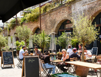 People sitting outside of restaurants and bars in Deptford.